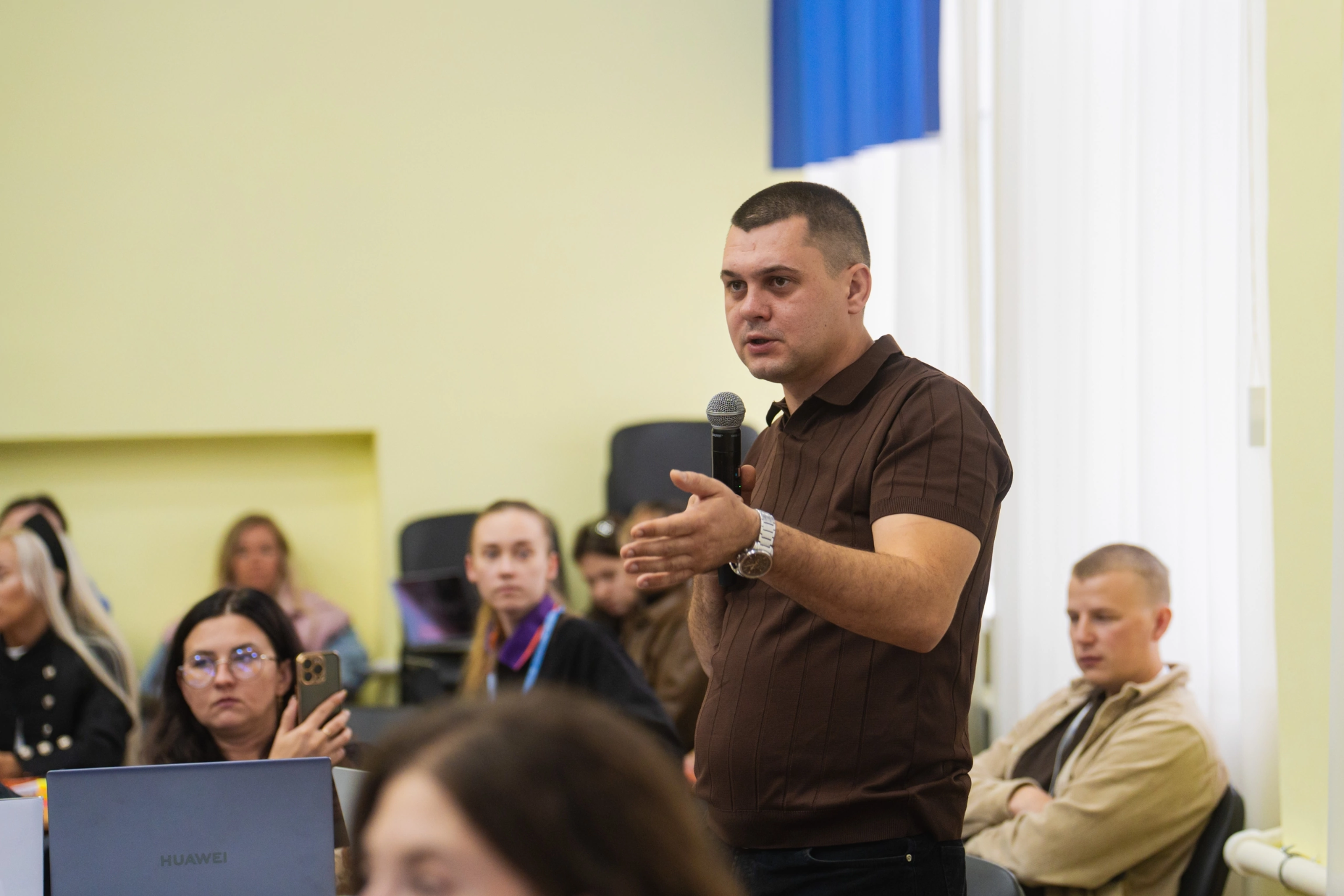 Выступление с микрофоном перед участниками встречи
